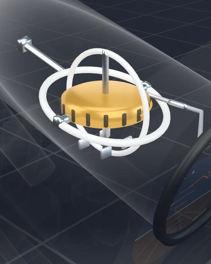 A close view inside a see-through attitude indicator case: a gold spinning wheel held in two white rings, one inside the other, on a dark grid.